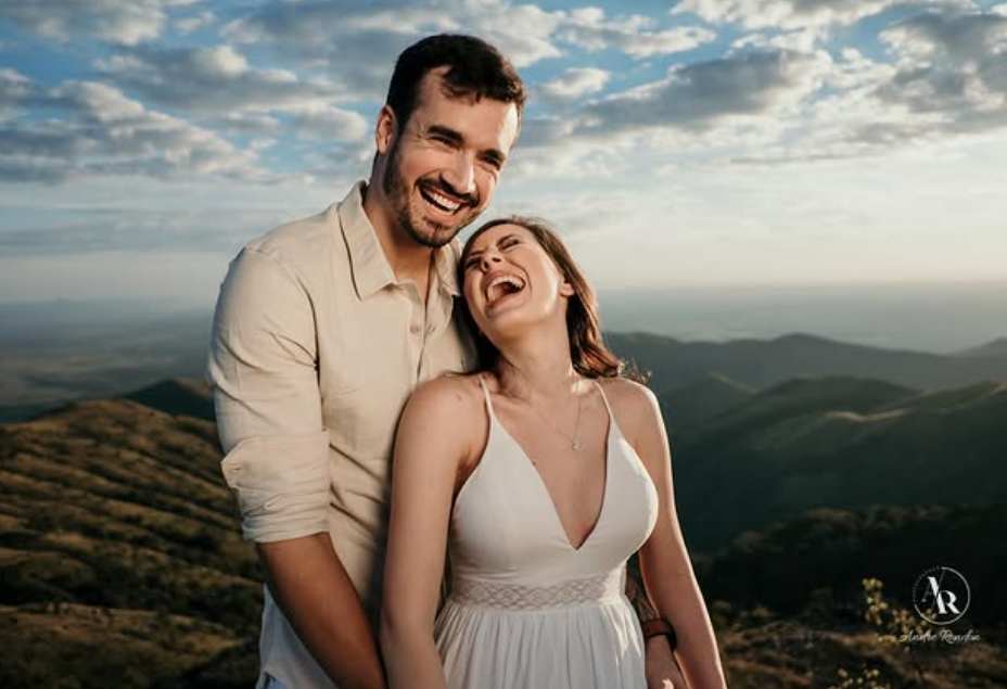Couple laughing on a mountain at sunset